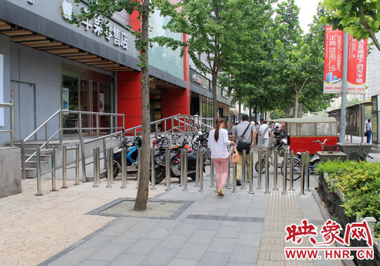 圖中道路左側(cè)的無(wú)障礙通道被鋼管隔離,右側(cè)的盲道也被侵占。