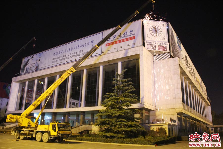 21點(diǎn)50分，切割機(jī)開始對(duì)中間最小的一塊牌進(jìn)行切割。頂著“呼呼”的寒風(fēng)，巨大廣告牌上火花四濺。