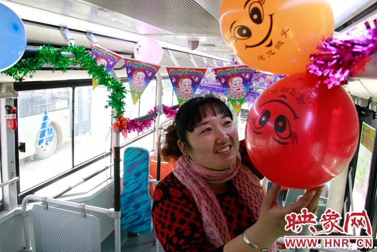 鄭州快速公交B3區(qū)間線車長李鵬云在車廂里懸掛氣球，布置圣誕車廂，營造歡樂圣誕氛圍