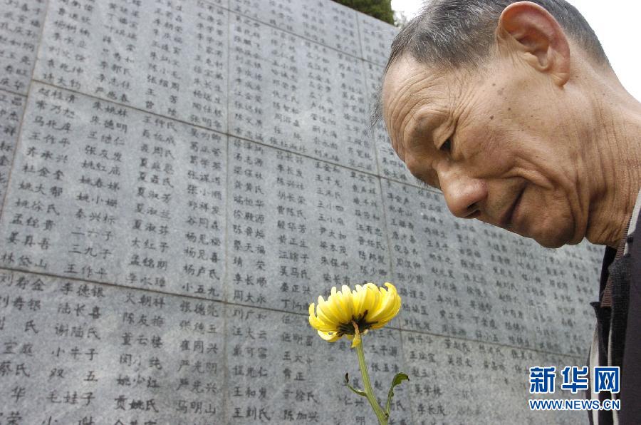 2006年4月5日，74歲的南京大屠殺幸存者佘子清手捧鮮花，祭奠被日軍殺害的母親。