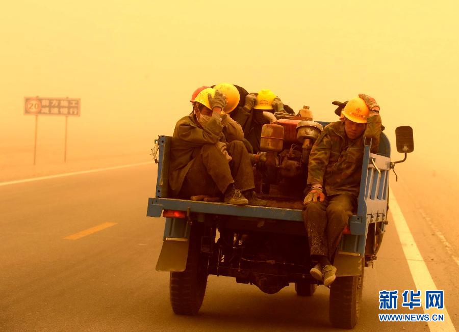 4月23日，一輛拉載公路施工人員的三輪車在沙塵暴中行駛在酒泉市瓜州縣城郊的公路上。