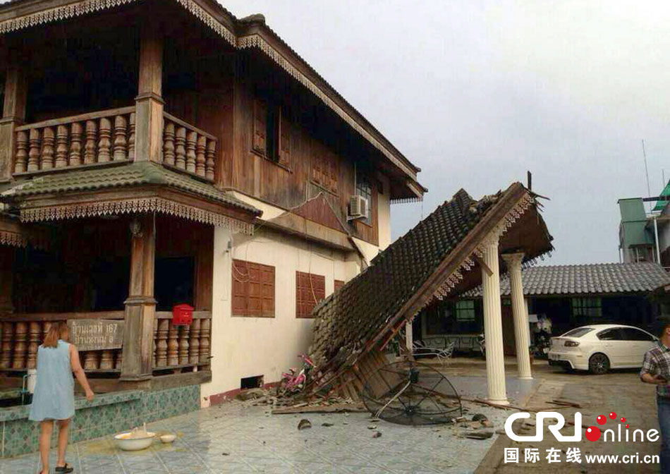 當(dāng)?shù)貢r(shí)間2014年5月5日，泰國清萊，一名婦女看著受損的房屋。 圖片來源：東方IC