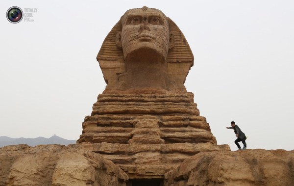 石家莊郊外，一名男子與山寨版獅身人面像合影留念。