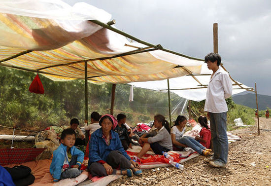 暴雨馬上來臨，村民們在簡易帳篷下躲雨。澎湃新聞 程藝輝 圖