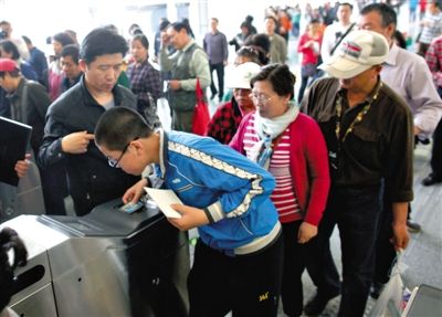 去年5月5日，14號(hào)線園博園站，乘客刷卡出地鐵。北京公交地鐵將實(shí)行計(jì)程票制，多乘坐多付費(fèi)。