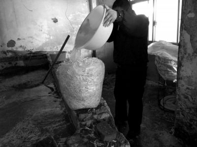 作坊內(nèi)工人用攪拌有漂白粉的藥水給豆芽增白。