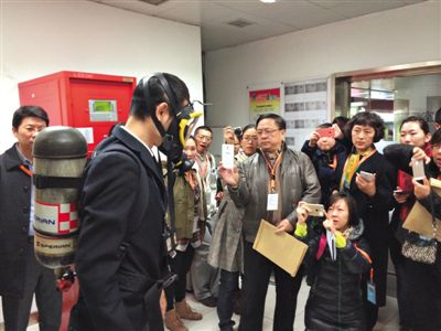昨天，地鐵4號線北京南站站，地鐵工作人員為人大代表演示應(yīng)急氧氣瓶佩戴方式。新京報記者