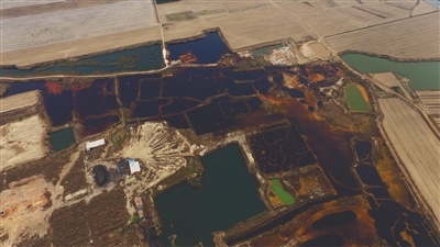 4月19日，廊坊市大城縣南趙扶鎮(zhèn)，津保路以北約八九百米處，一個(gè)巨大的污水坑中，水體呈現(xiàn)紅褐色。 新京報(bào)記者 尹亞飛 攝