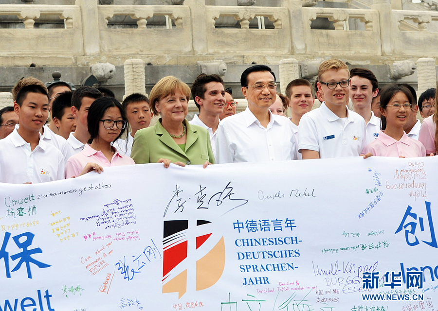 李克強(qiáng)同默克爾與青少年在天壇祈年殿前合影留念。