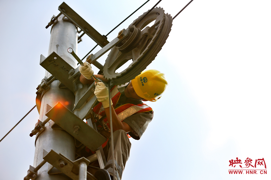 被太陽(yáng)暴曬后的線桿碰著就能燙紅皮膚，可是檢修員此刻也顧不得許多