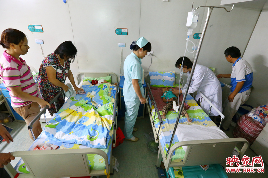 手術(shù)前，畫面右側(cè)的大龍正在接受醫(yī)生的檢查，左側(cè)的小龍還在熟睡。