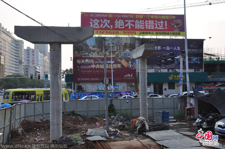 過(guò)街天橋一側(cè)的橋樁早已打好,可是對(duì)面的郵政銀行網(wǎng)點(diǎn)依舊在照常營(yíng)業(yè)。