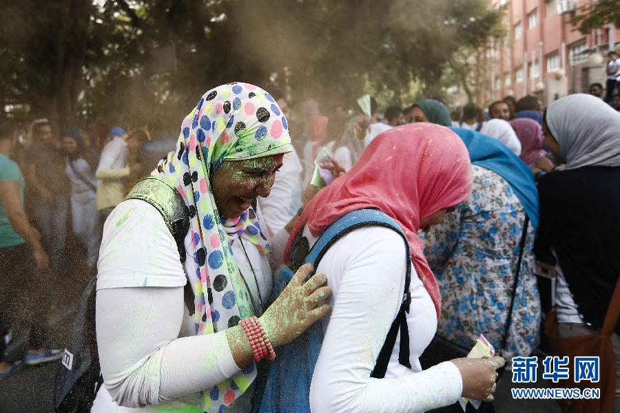 10月16日，在埃及首都開(kāi)羅，兩名女青年在“彩色跑”活動(dòng)中躲避人們拋撒的彩色粉末。