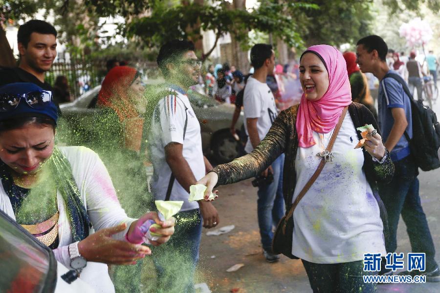 10月16日，在埃及首都開(kāi)羅，一名女青年在“彩色跑”活動(dòng)中拋撒彩色粉末。
