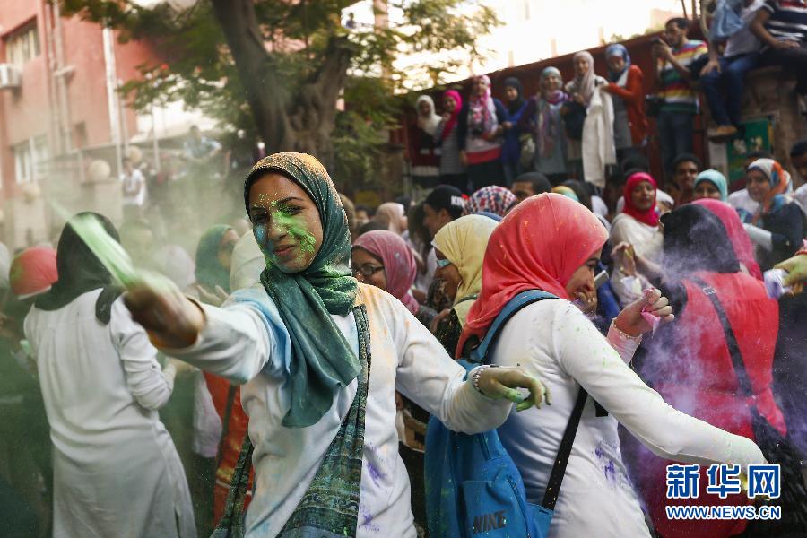 10月16日，在埃及首都開(kāi)羅，一名女青年在“彩色跑”活動(dòng)中拋撒彩色粉末。