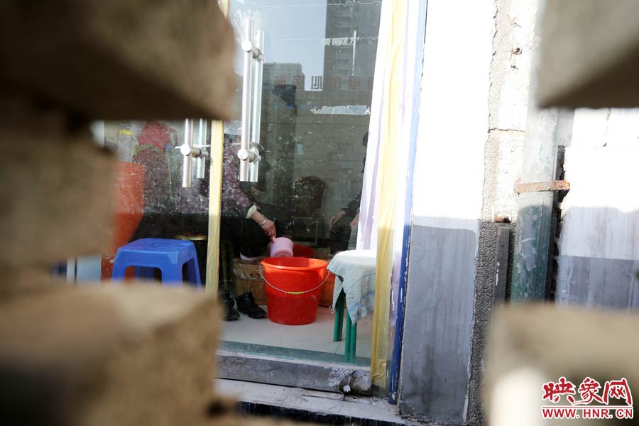 墻內(nèi)一家店面正常營(yíng)業(yè)。