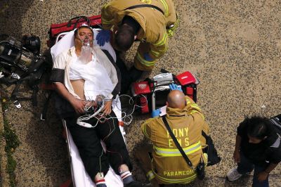 2日，救援人員在美國(guó)紐約地鐵事故車輛內(nèi)緊急疏散一名受傷乘客。圖/CFP