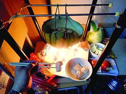 兩張椅子被面對面疊在一起，穿了兩根線的西瓜皮就懸空在椅腳中間，下面有蠟燭加熱，這就是西瓜火鍋。