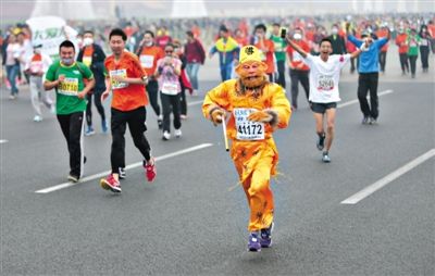 長安街，一名打扮成孫悟空的參賽者在北馬隊(duì)伍里飛奔。 本版攝影/新京報(bào)記者 吳江 李飛 王嘉寧 吳江