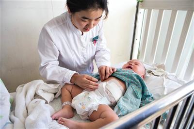 昨日，北京兒童醫(yī)院，護(hù)士為即將出院的被扎鋼針女嬰檢查傷口恢復(fù)情況。記者 高瑋 攝