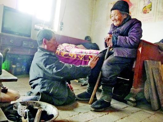 52歲的劉蘭山每天靠爬行照顧90歲的老母親。孫國(guó)祥 攝