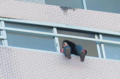 28樓的窗臺(tái)上坐著一名女子，其兩條腿耷拉在室外，不停地?cái)[動(dòng)。