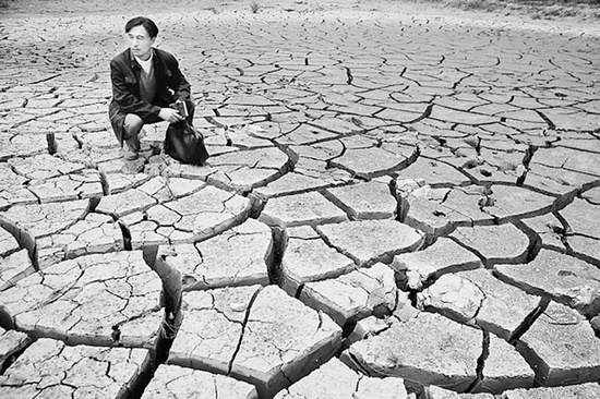 蹲在干涸的田地里，焦裕祿為饑餓的百姓揪心不已 《焦裕祿》劇照